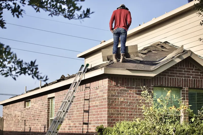 Professional roofer working on a residential roof in Harford Mills